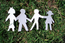 Paper cut out of family on grass
